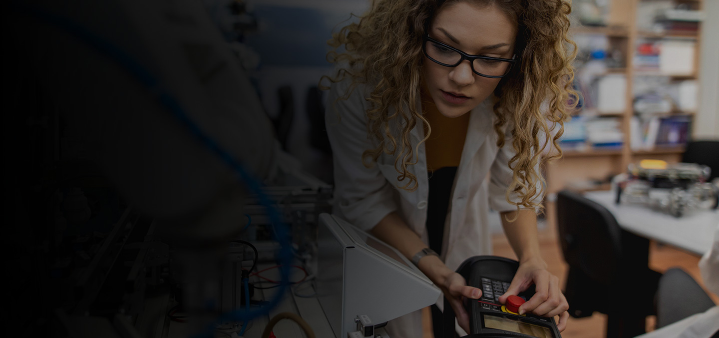 Female workforce professional performs maintenance on a manufacturing machine