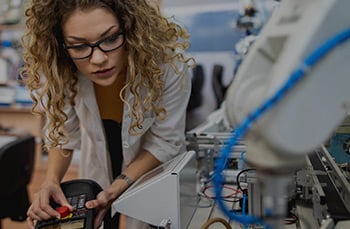 Female workforce professional performs maintenance on a manufacturing machine